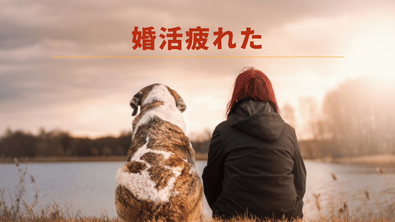 愛犬と河川敷に座る女性